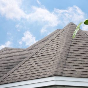 edge of Roof shingles on top of the house, dark asphalt tiles on the roof background.
